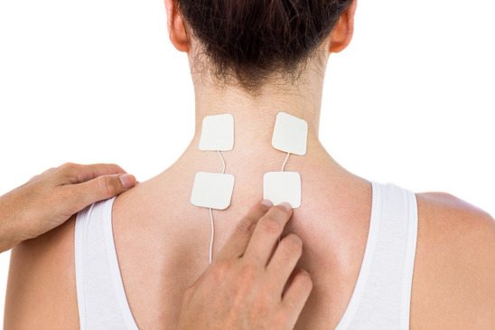 Woman having electrotherapy on white background
