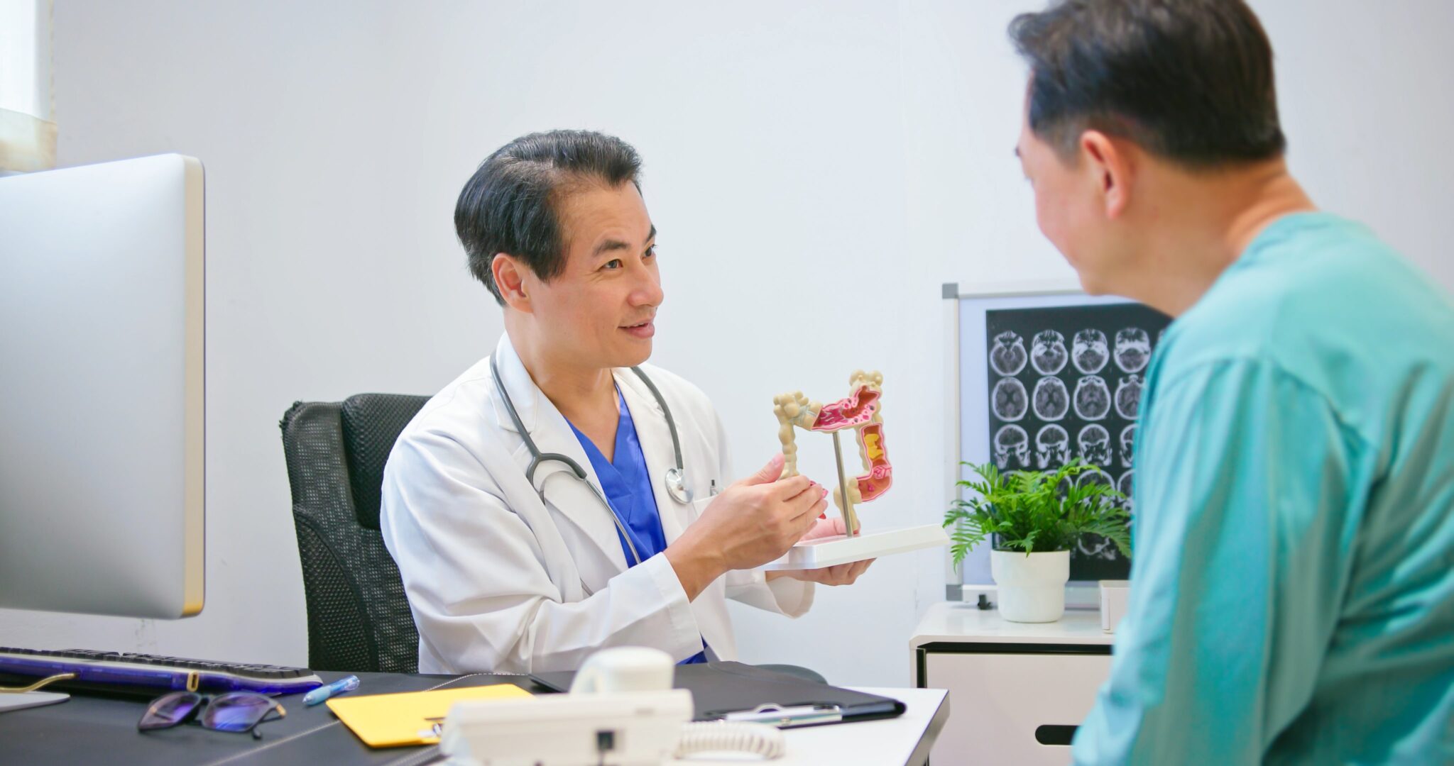 a doctor using a colon diagram to explain how to prevent colon cancer