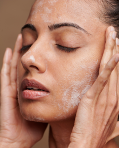 young woman washing her face as part of her ski care aesthetics routine