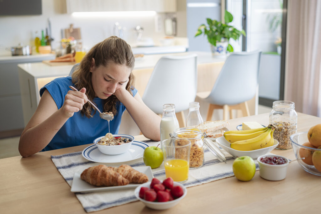 Sad woman eating oatmeal